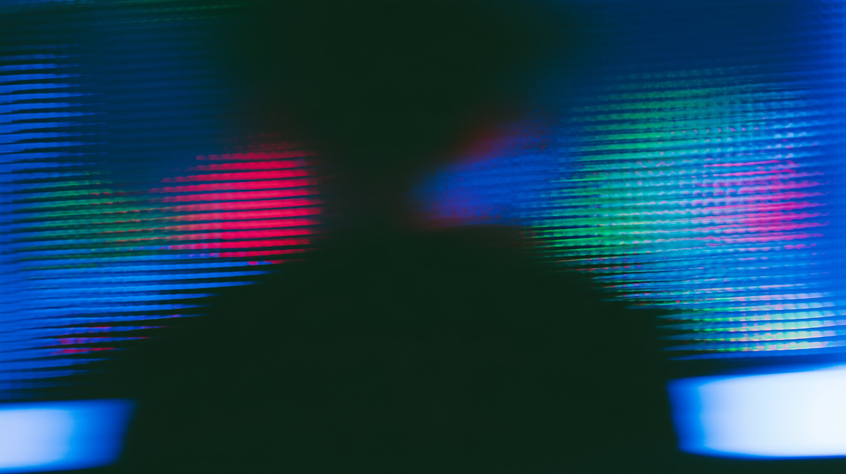Abstract blue, green, and pink light patterns on a dark background